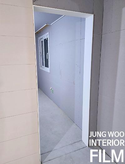 회색 벽면과 창호가 설치된 복도 공간