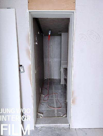 회색 타일 바닥과 전기 소켓이 설치된 복도