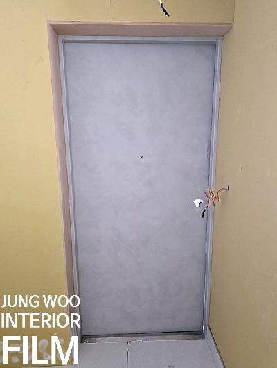 노란 벽면과 회색 문, 노출된 전선이 보이는 공간