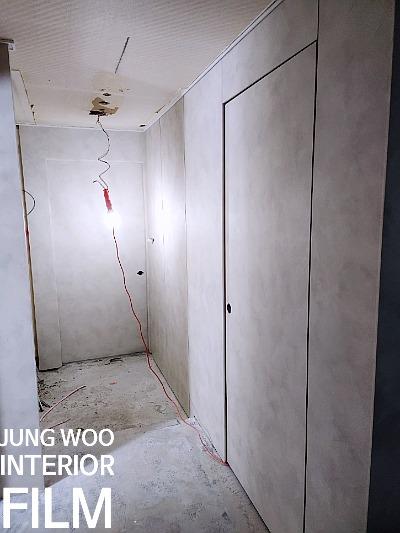 마감 전 상태의 흰색 벽과 흙바닥이 보이는 복도