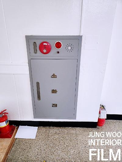 회색 금속제 소화기 캐비닛과 주변의 소화기들