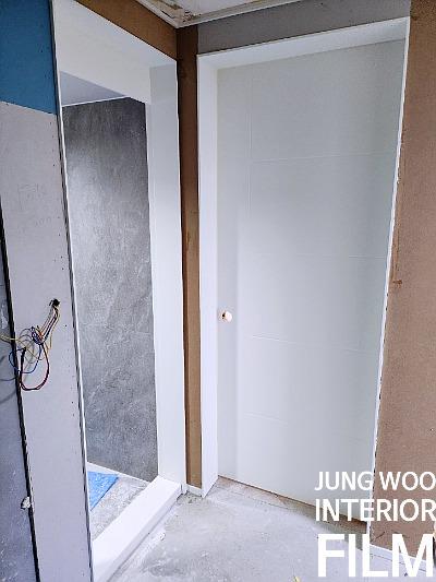 전선이 노출된 벽면과 흰색 도어가 설치된 내부