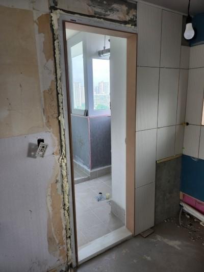 문틀 주변 거품과 전기 스위치가 보이는 벽면