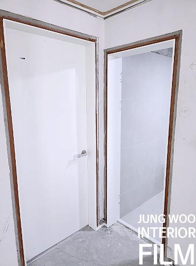 철거된 문틀과 흰색 문이 보이는 공간