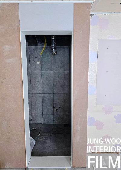 회색 타일 벽과 노출 배관이 보이는 내부 공간