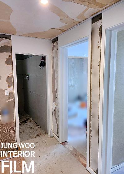 도배 작업과 필름 마감이 동시에 진행되는 복도
