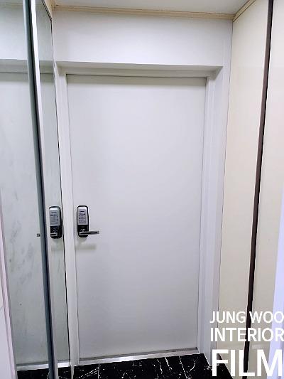 흰색 도어와 검은색 타일 바닥이 보이는 현관 전경