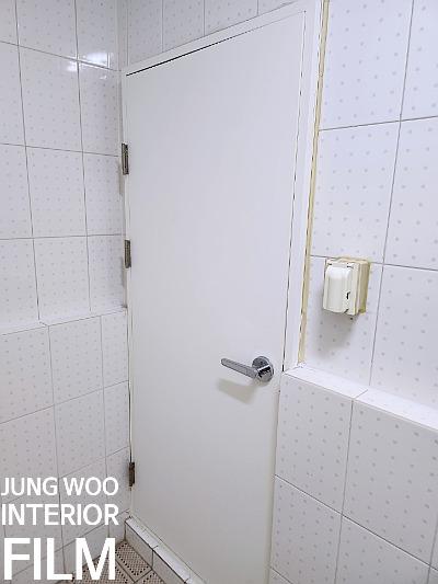 흰색 타일과 문이 설치된 공간의 시공 전 모습