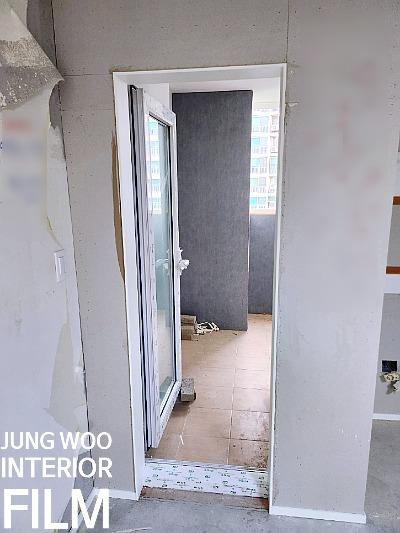 타일 바닥 위로 설치된 흰색 프레임의 슬라이딩 도어