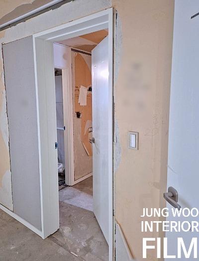 전기 스위치가 설치된 벽면과 흠집이 보이는 복도 문