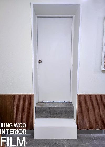 흰색 문과 계단이 있는 현관의 시공 전 상태