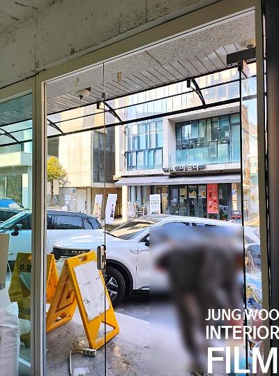 유리문을 통해 보이는 외부 건물과 차량 전경