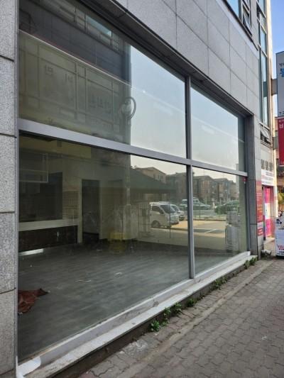 외부 풍경이 반사되는 유리창과 어두운 타일 바닥