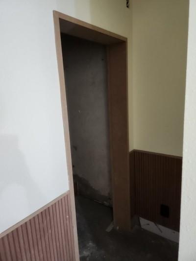 갈색 도어 프레임과 전기 소켓이 보이는 복도