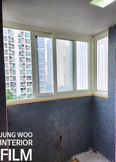 유리 패널 창호와 파란색 하단 마감재가 적용된 벽면