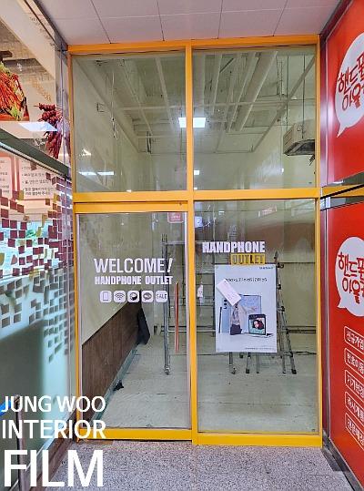 노란색 프레임이 적용된 상가 외부 출입구 전경