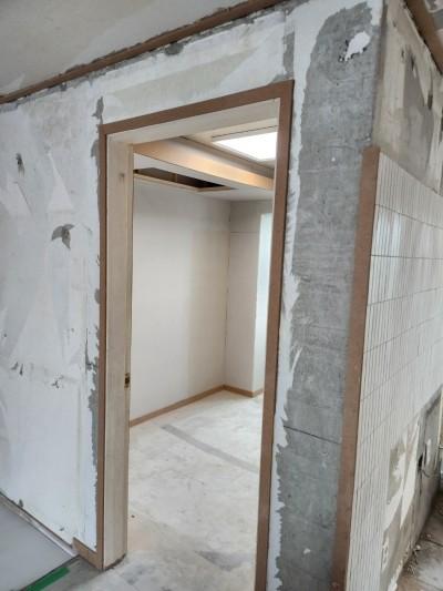 타일 바닥 위로 진행 중인 벽면과 문틀 마감 작업