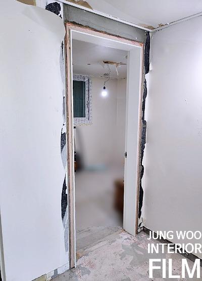 벽면 일부가 벗겨진 복도의 문틀 모습