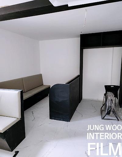 검은색 수납장과 베이지색 소파가 배치된 내부