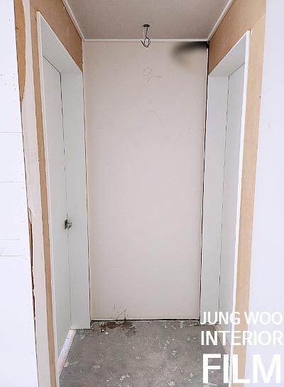 전선이 노출된 천장과 양쪽 문이 보이는 복도