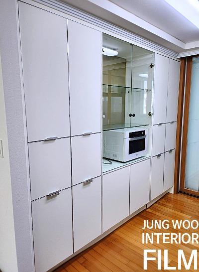 화이트 수납장과 유리 캐비닛이 배치된 모습