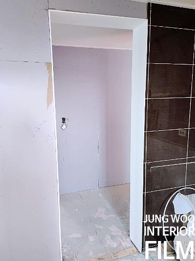 검은 타일 벽과 흰색 문틀이 있는 개방 공간