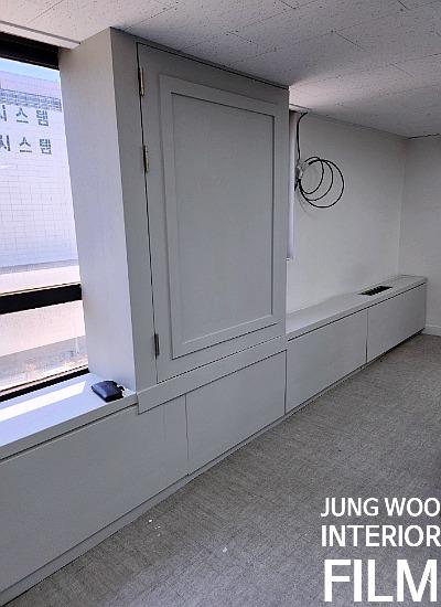 흰색 벽면과 회색 바닥이 대비되는 수납장 설치 구역