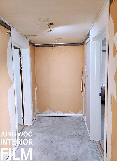 전선이 노출된 천장과 흰색 보조재가 덧대어진 문틀