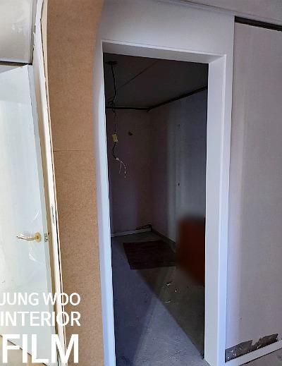 전선이 노출된 천장과 흰색 프레임의 문