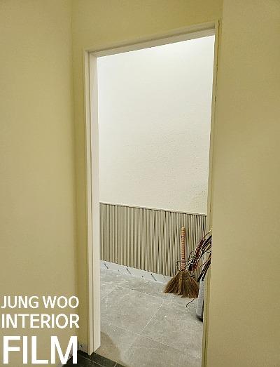 수직 라인 패턴 벽지가 시공된 현관 공간