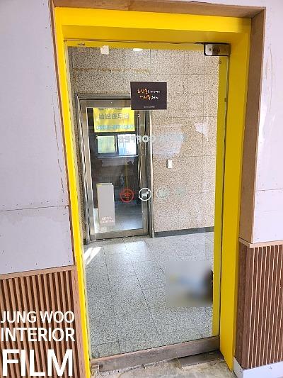 벽돌 패턴 타일과 노란색 프레임 문이 마주한 공간