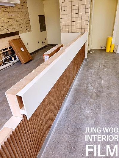 타일 패널 벽면과 구조물이 설치 중인 복도 공간