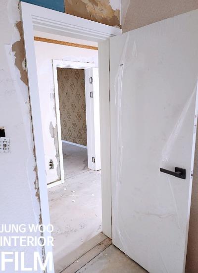 검은색 손잡이가 달린 문과 노출된 벽면
