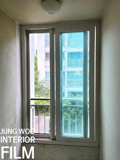 외부 건물과 나무가 보이는 창호 프레임 근접 촬영