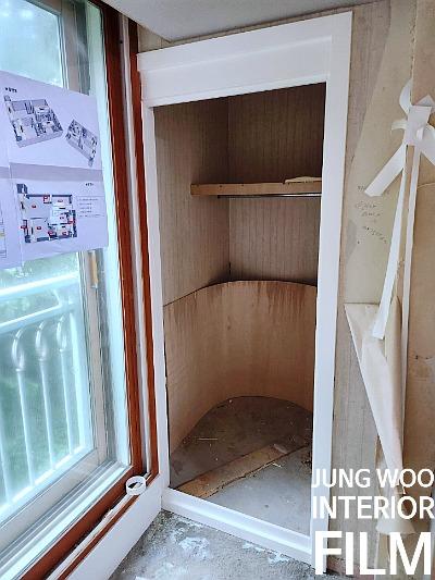 목재 구조물과 선반이 설치 중인 창호 주변
