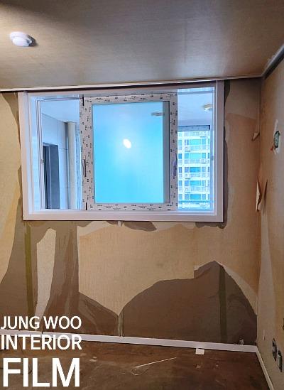 창호가 열려 있고 벽면에 흠집이 드러난 실내 공간