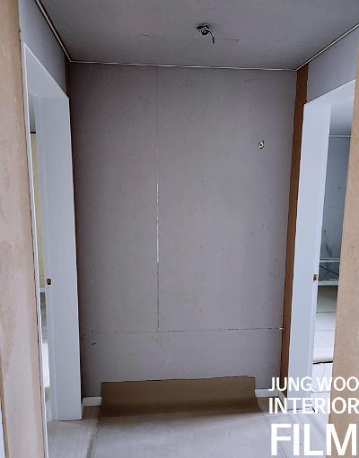 천장 카메라와 좌우 문이 배치된 흰색 벽면 공간