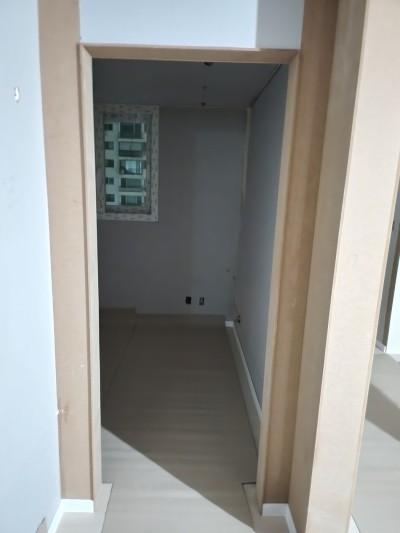 회색 벽면과 베이지색 마루가 깔린 복도