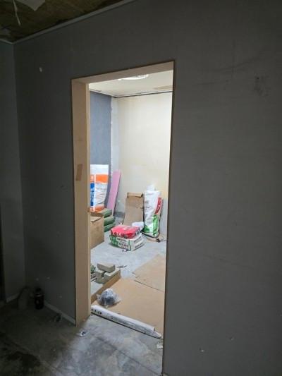 마감 전의 흰색 벽면과 콘크리트 바닥의 내부 공간