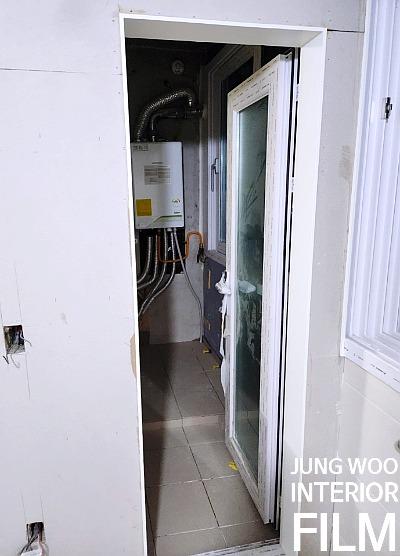 타일 바닥과 유리문, 보일러 배관이 보이는 공간
