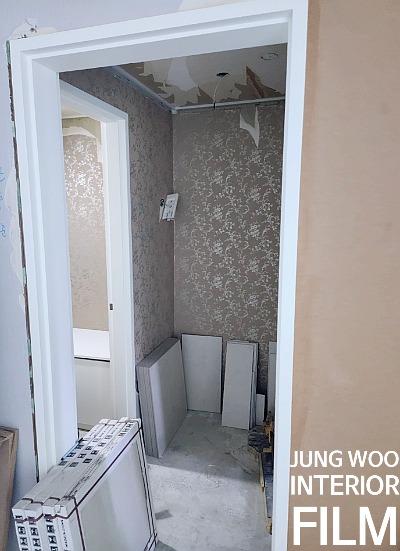 흰색 패널이 놓인 흙바닥 상태의 실내 공간