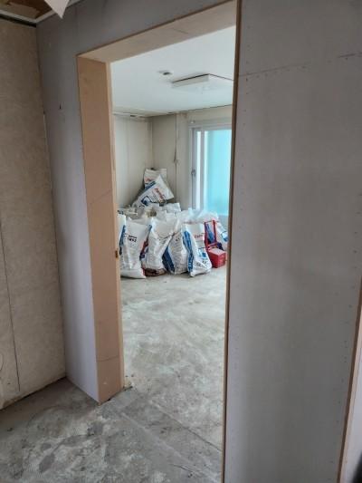 보라색 페인트가 칠해진 벽면과 콘크리트 바닥의 방 내부