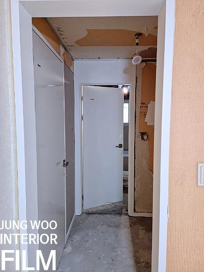 콘크리트 벽과 보드가 노출된 복도의 철거 상태