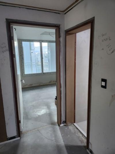 벽면 흠집과 손글씨가 보이는 복도와 거실 연결부