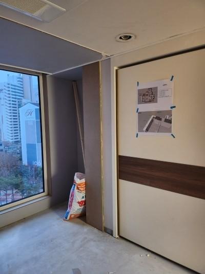 도면이 붙은 벽면과 베이지색 패널의 창가