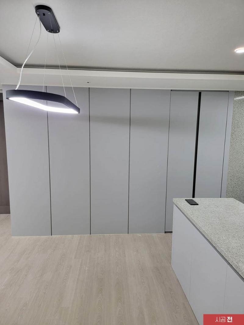 회색 수납장과 흰색 상판이 보이는 주방 시공 전 모습