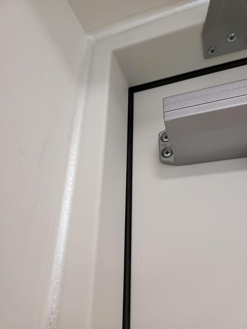 금속 도어 힌지와 흰색 벽면의 접합 시공 과정