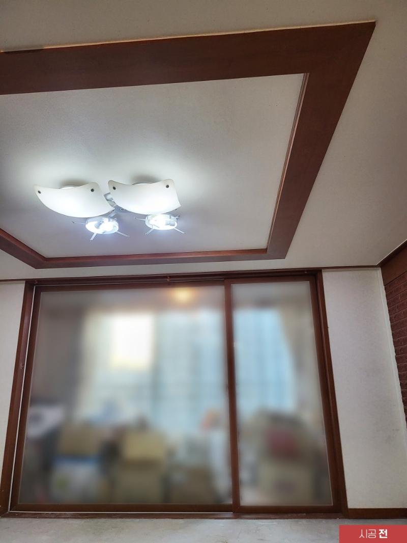 나무색 프레임의 천장 조명과 시공 전 공간