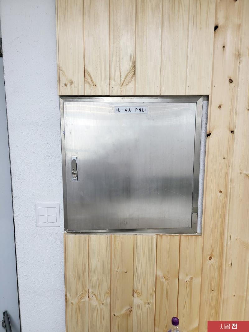 스테인리스 금속 상자와 주변 목재 패널 마감
