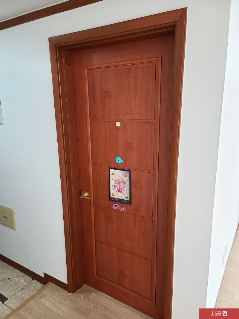 파란 보호 테두리가 보이는 시공 전 도어와 프레임